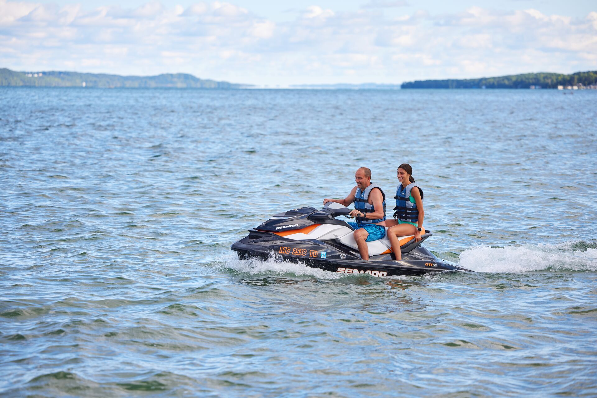 A man and girl on a personal watercraft, get your Texas jet ski license concept. 