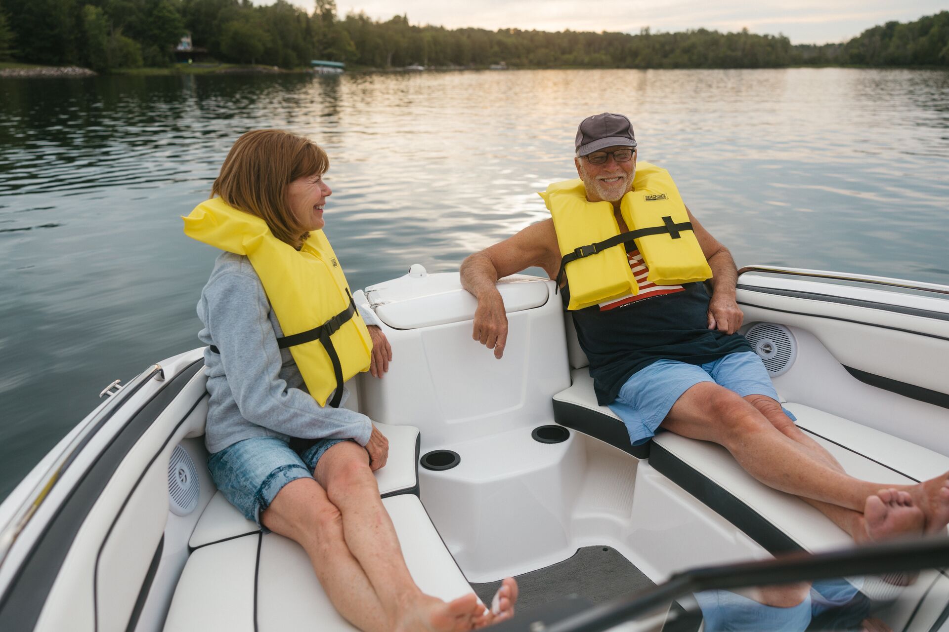 Two adults wearing life jackets on a small boat.