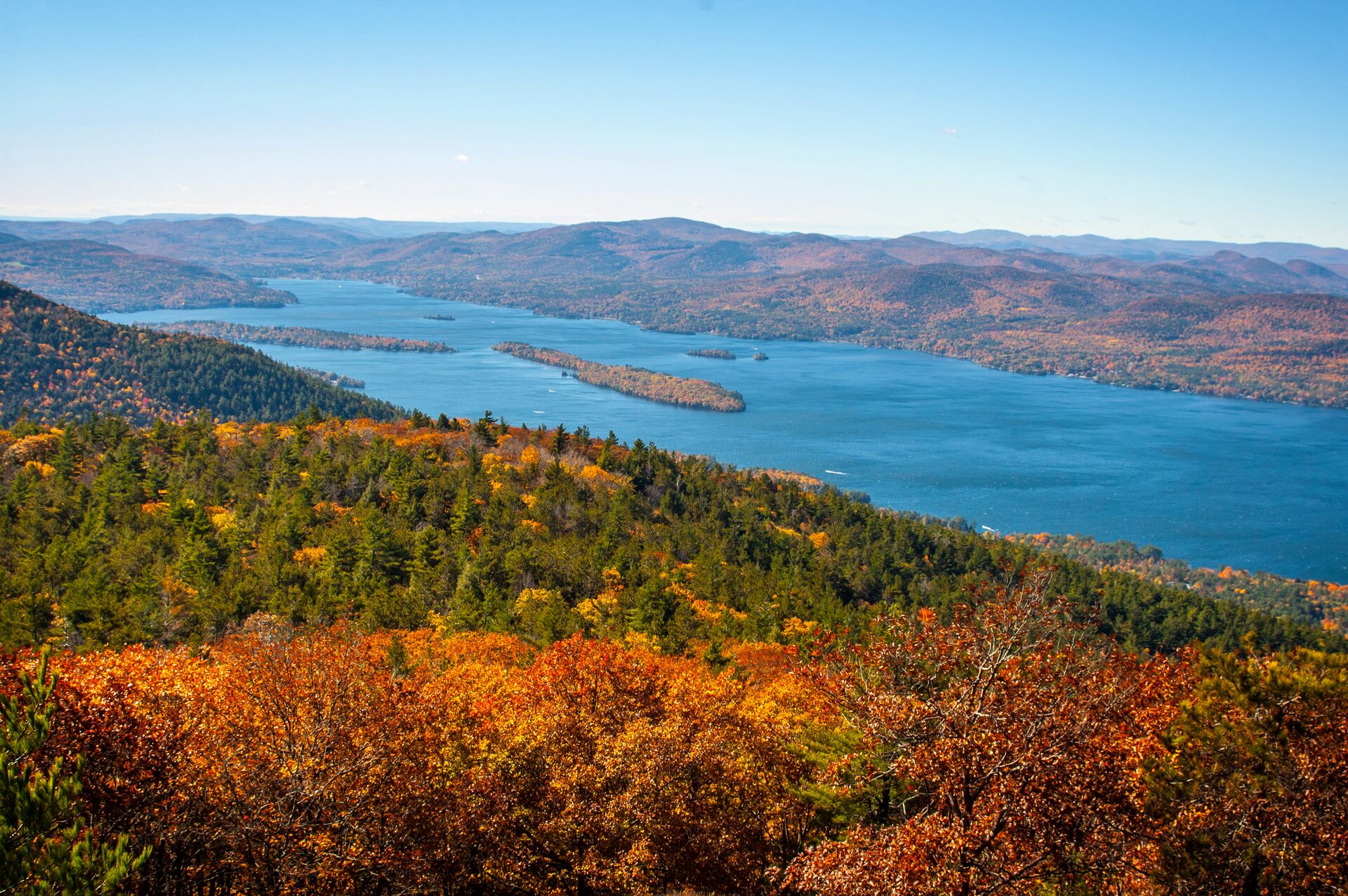 Overhead view of a lake surrounded by trees and hills.