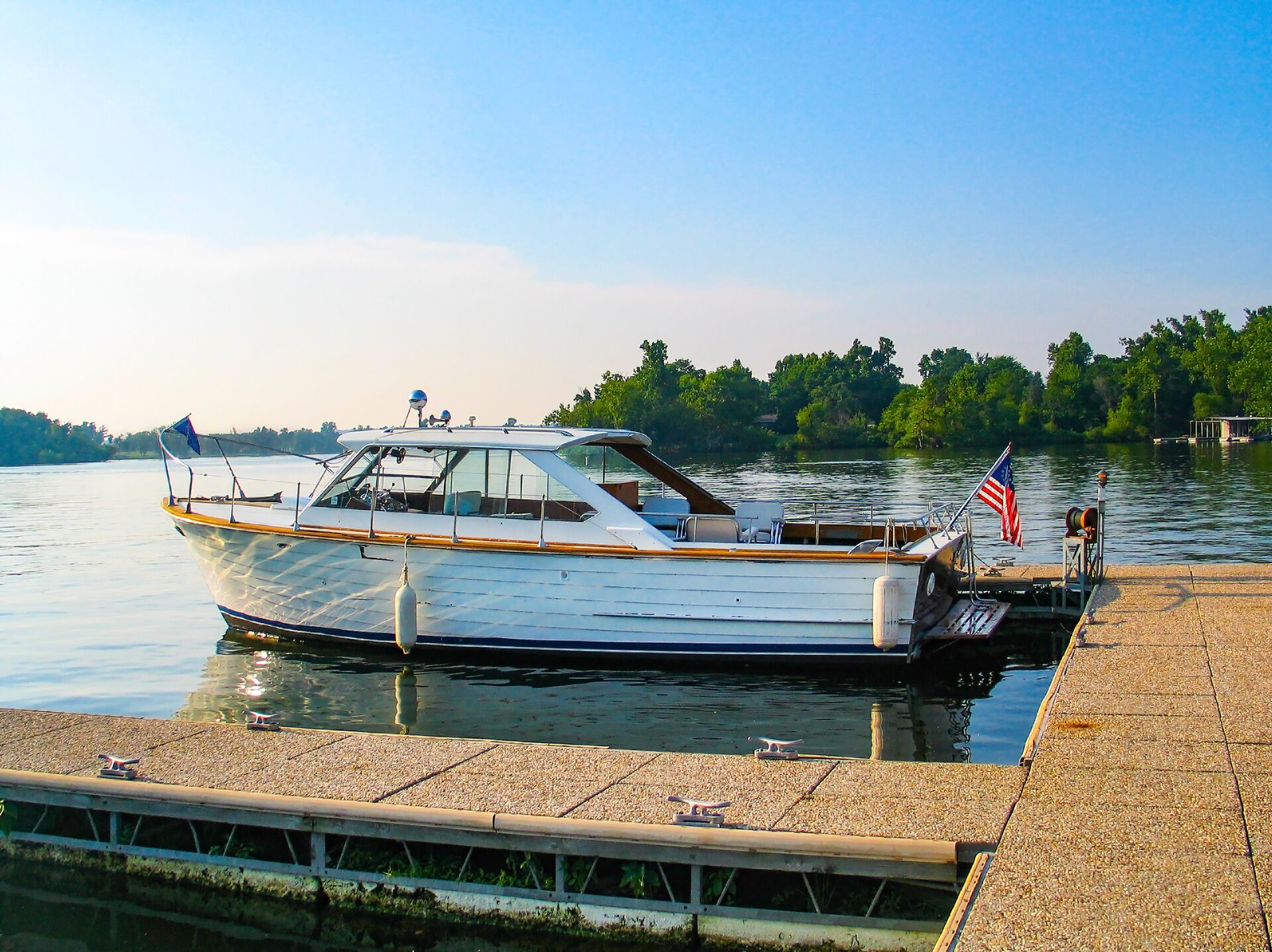 Wooden boat with US flag docked at lake, best boating lakes in the US concept.