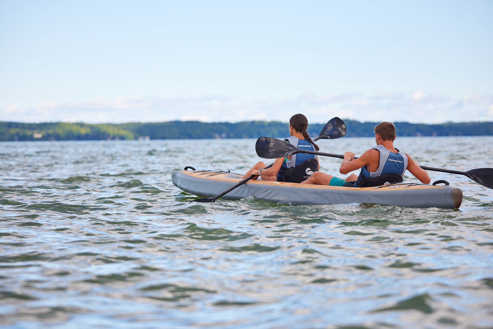 Young boy and girl paddle kayak on lake, best boating lakes in Washington State concept.