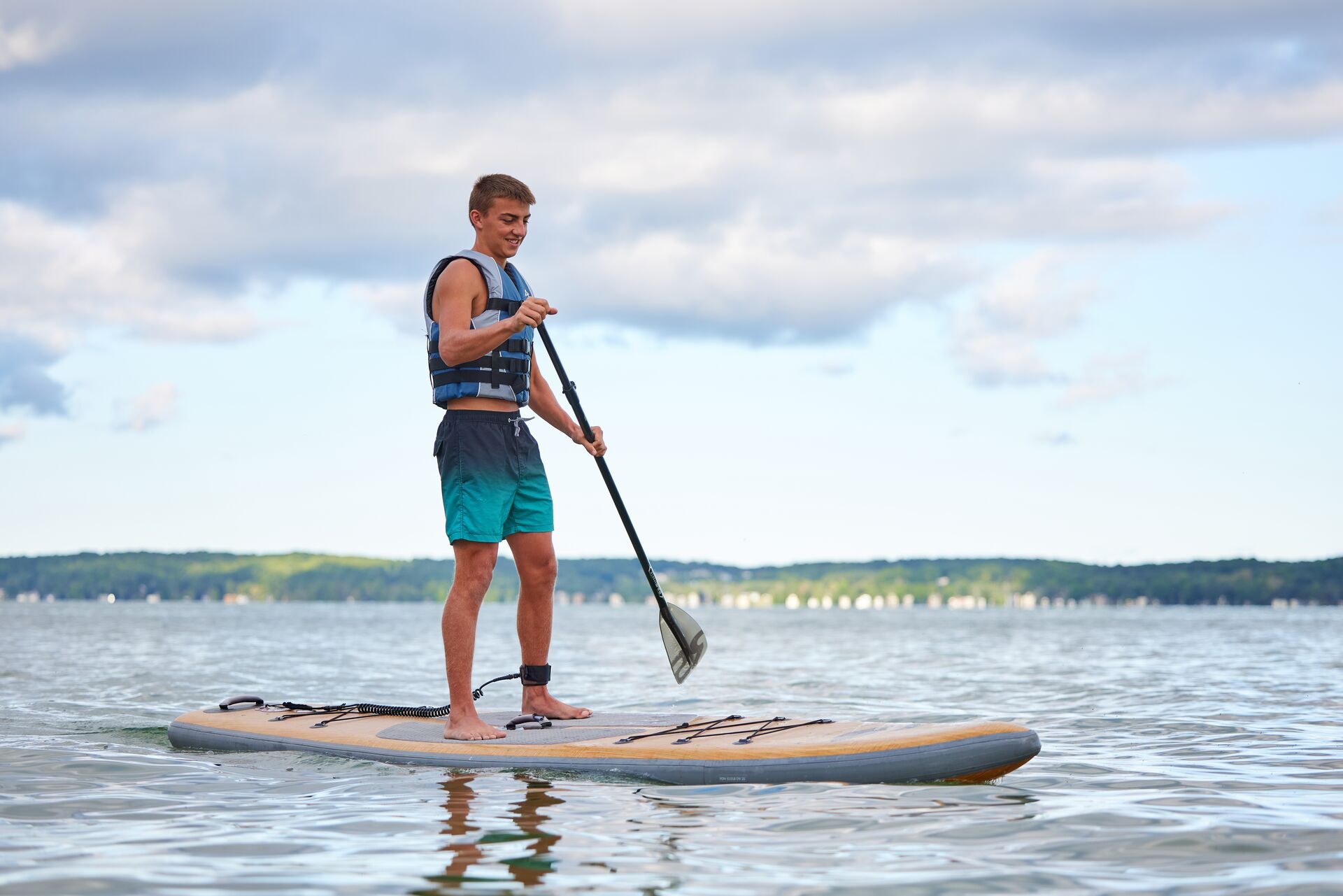 Boy on a paddleboard on a lake, best boating lakes concept. 