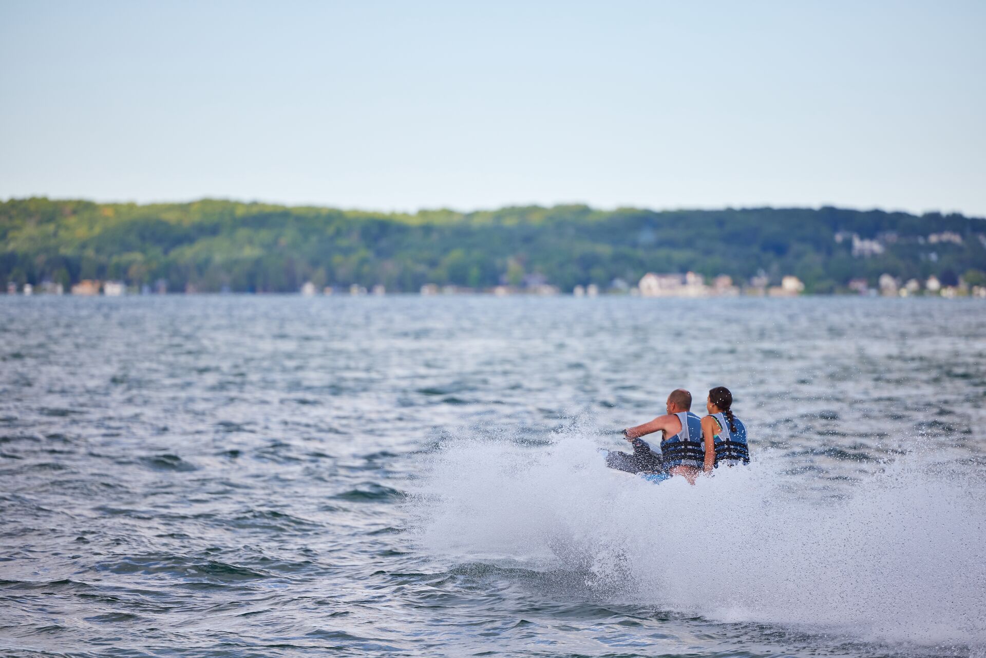 Man and girl ride a jet ski on a lake. 