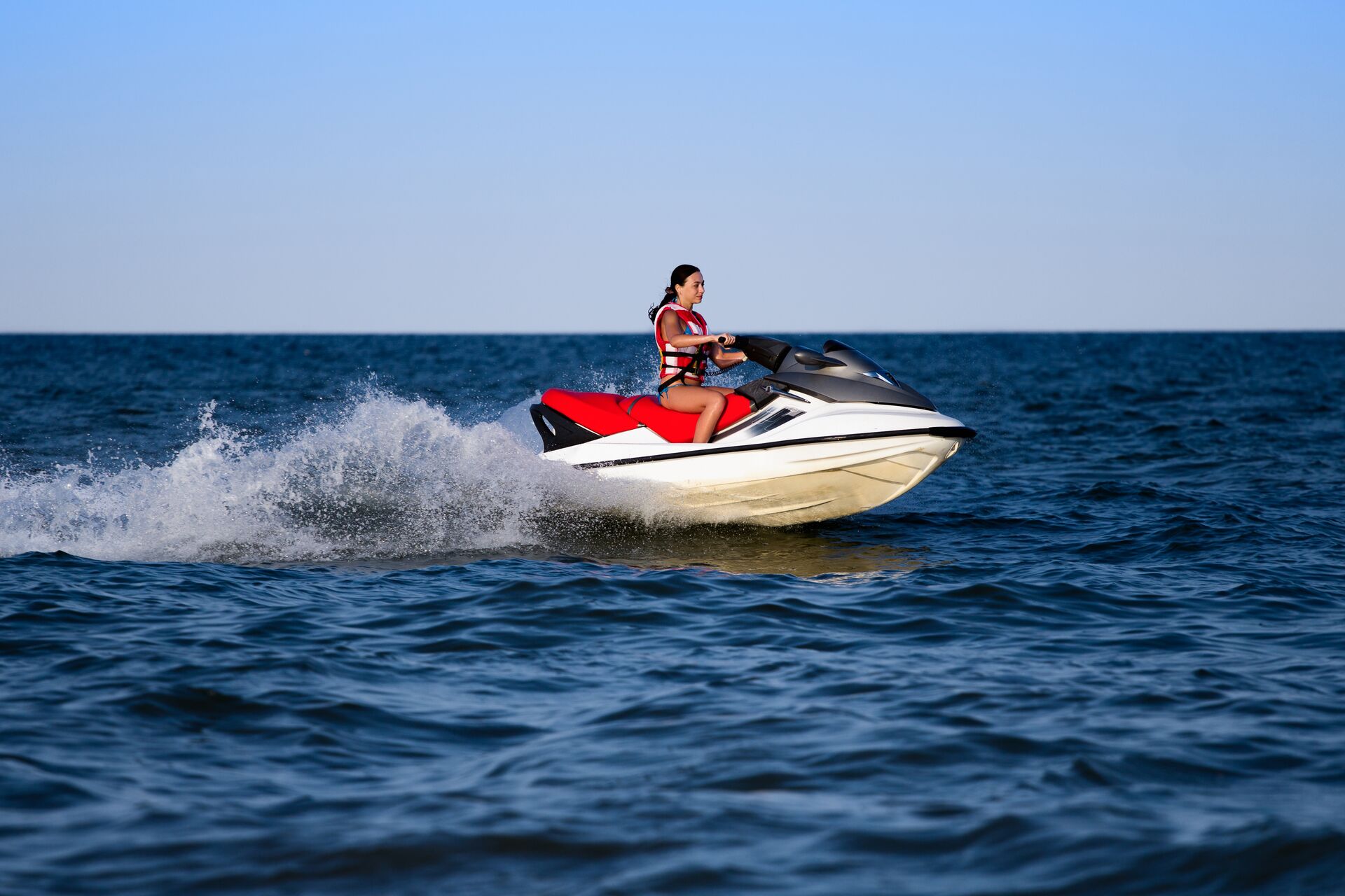 Girl wears life jacket to drive jet ski, New York state jet ski license concept. 