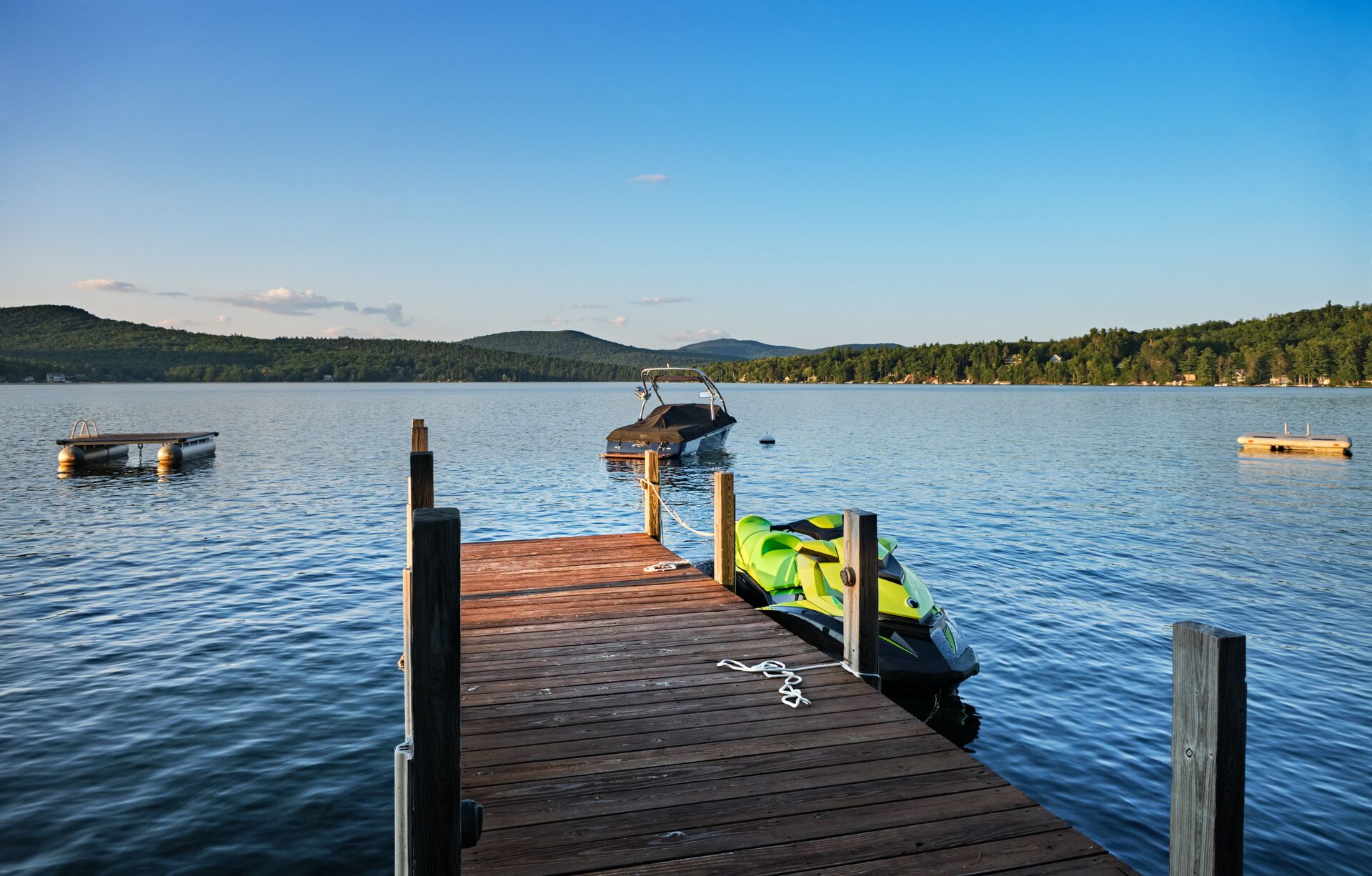 Dock on a lake with a boat and PWC, get a Nevada boating license concept. 