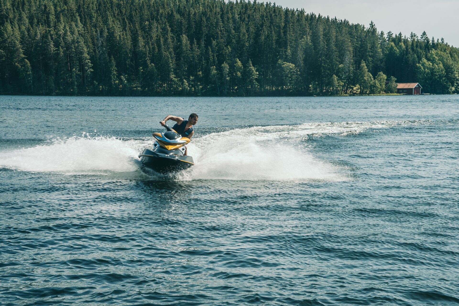 Young man turns on a jet ski on a lake. 