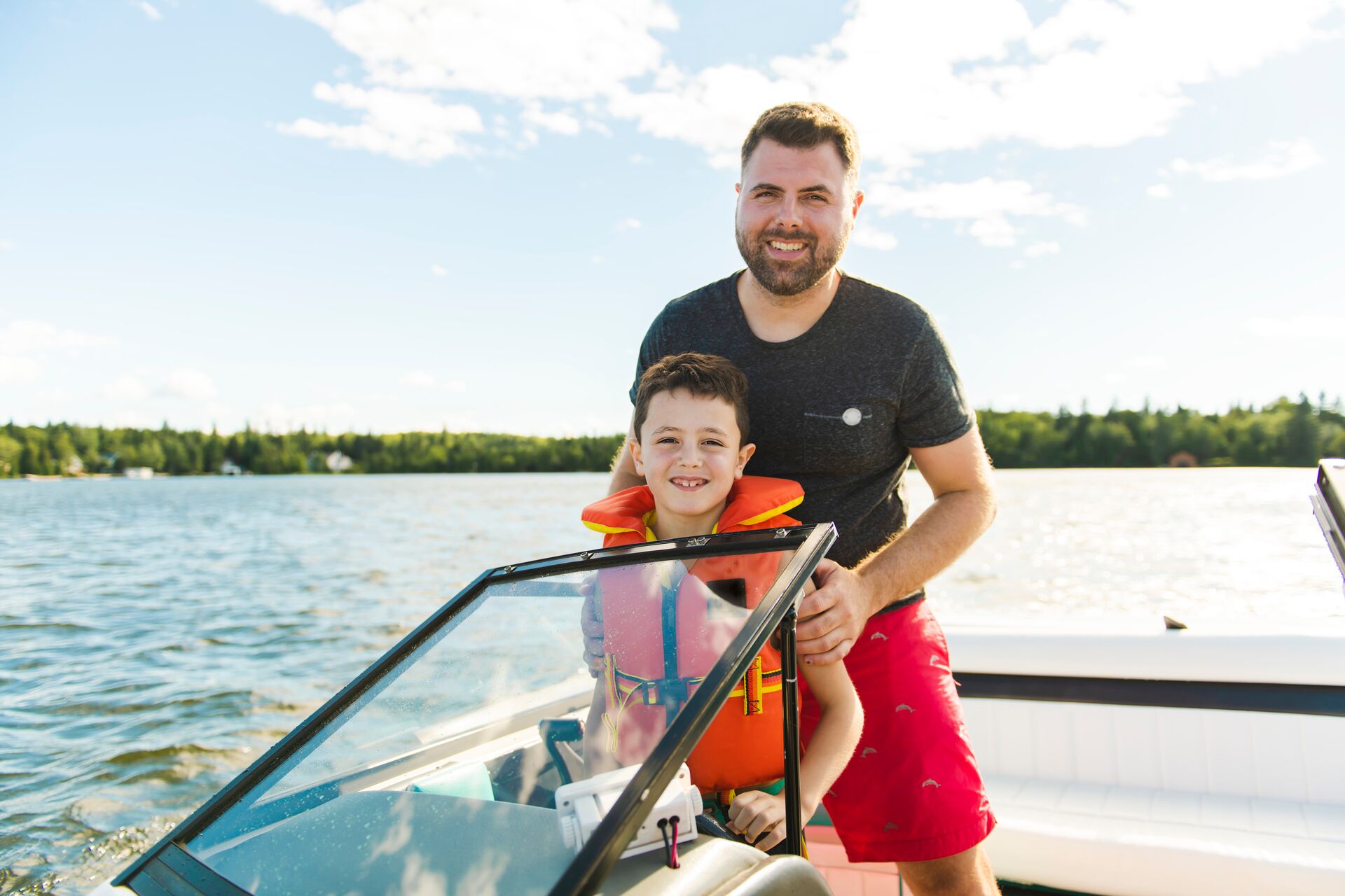 Smiling man and boat at helm of boat, best boating lakes in FL concept. 