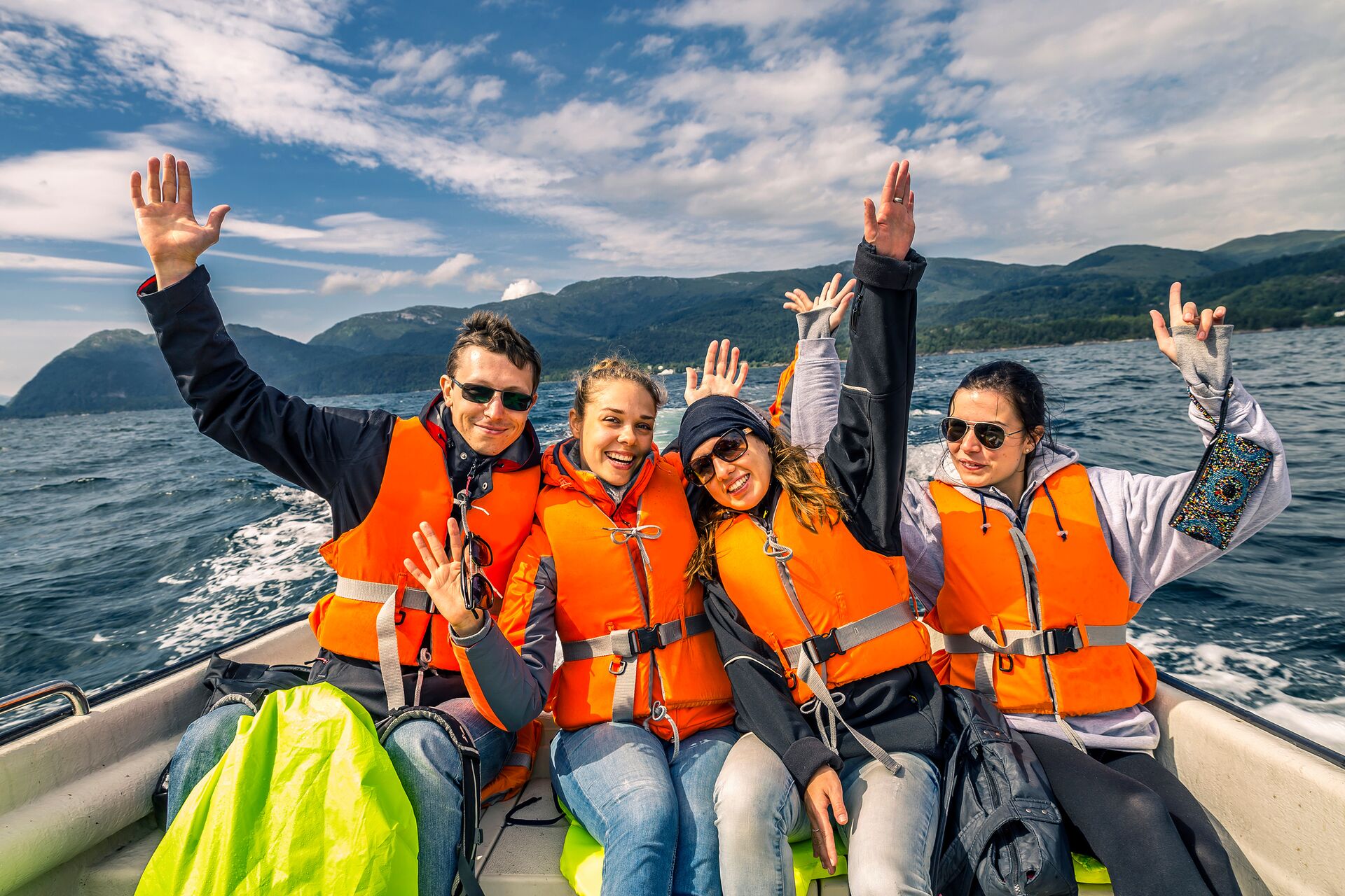 Four people in orange life jackets on a boat, know your boat capacity concept. 