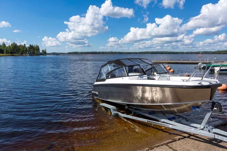 A boat on a trailer entering the water. 