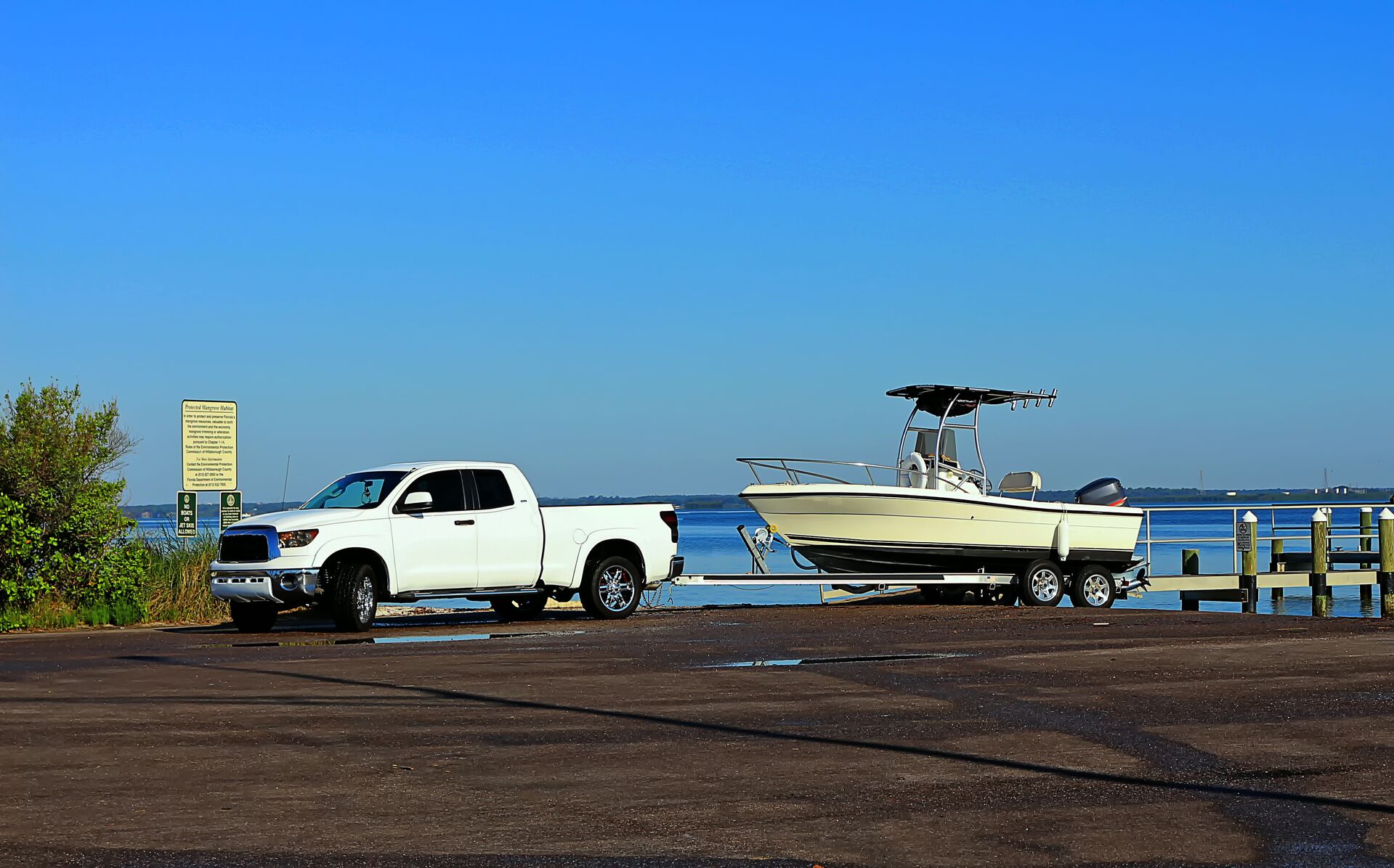 A truck attached to a trailer with a boat on it, how to launch a boat concept. 