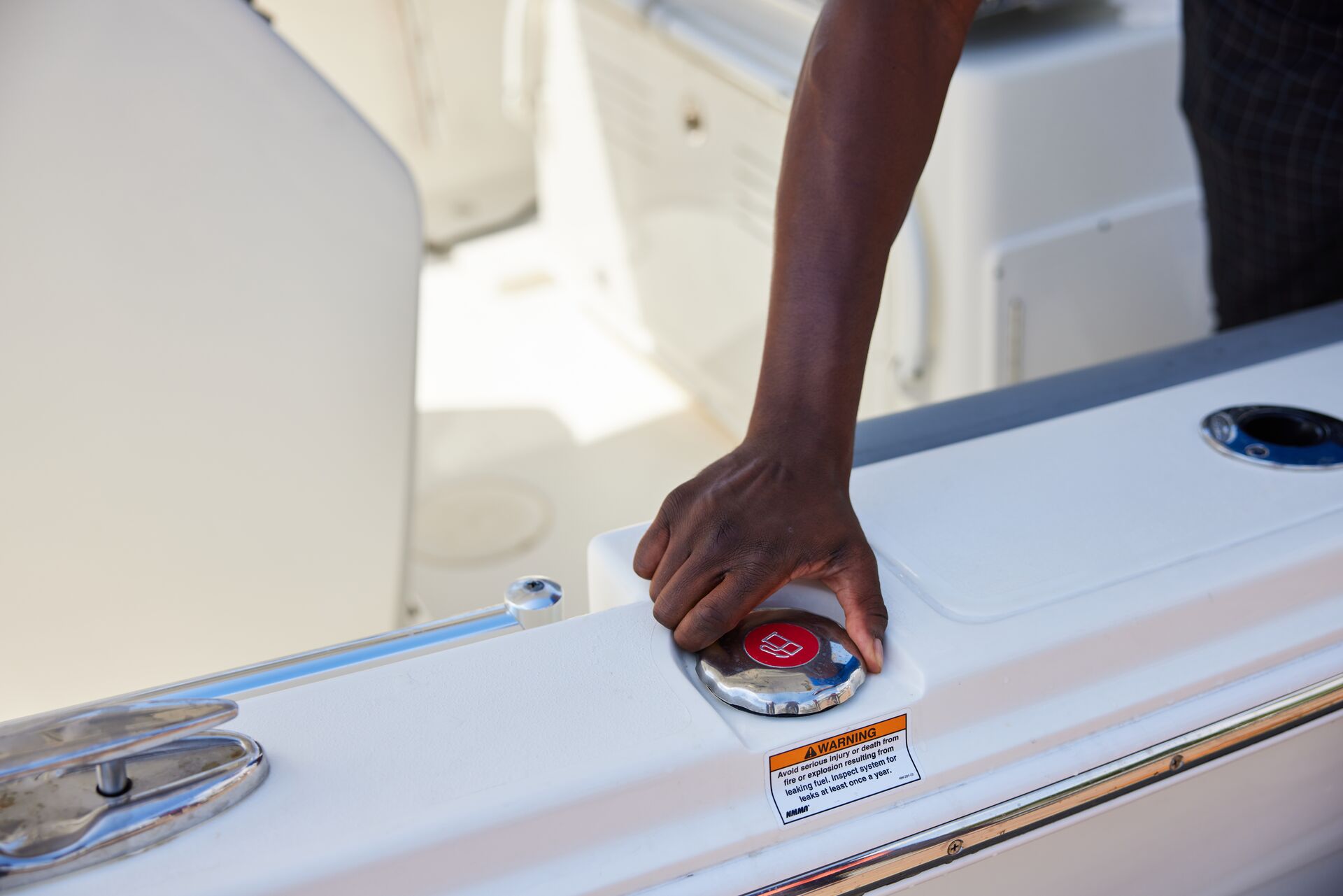 A hand opens the place to add fuel to a boat. 