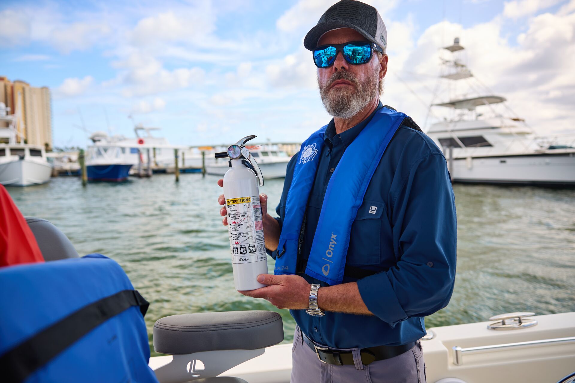 A boat operator holds a fire extinguisher.