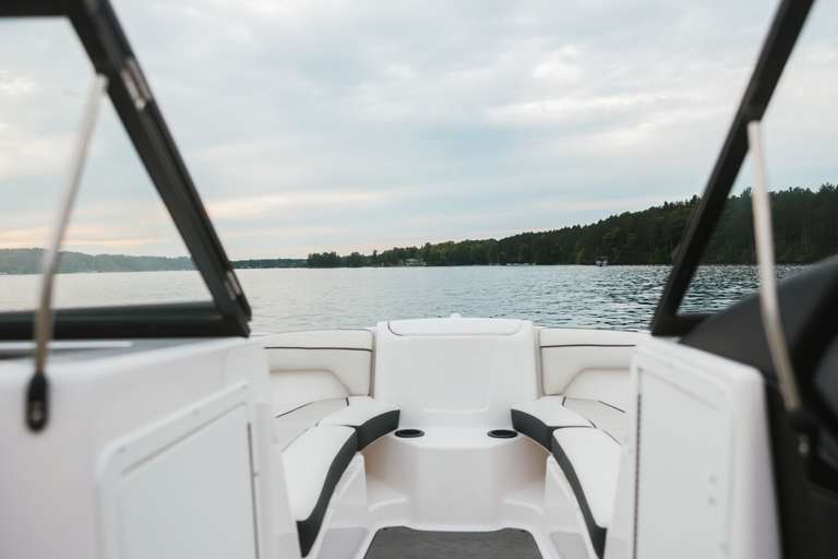 The view of a the water looking out over the back of a boat. 
