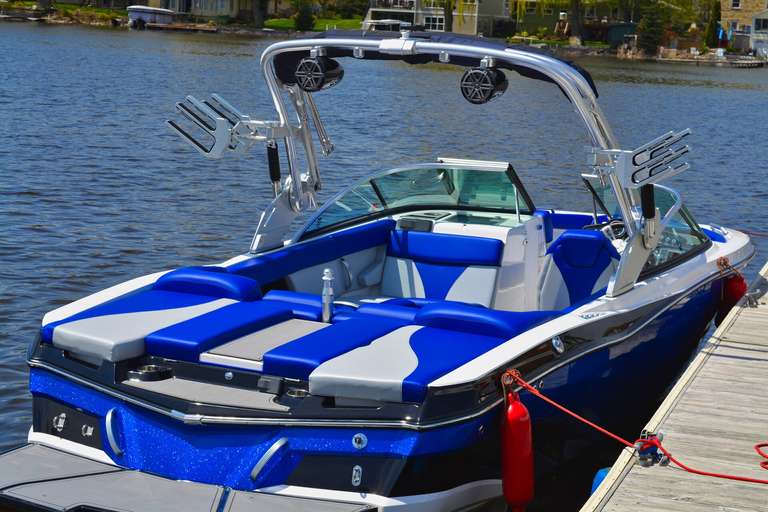 A blue boat moored at a dock on the water. 
