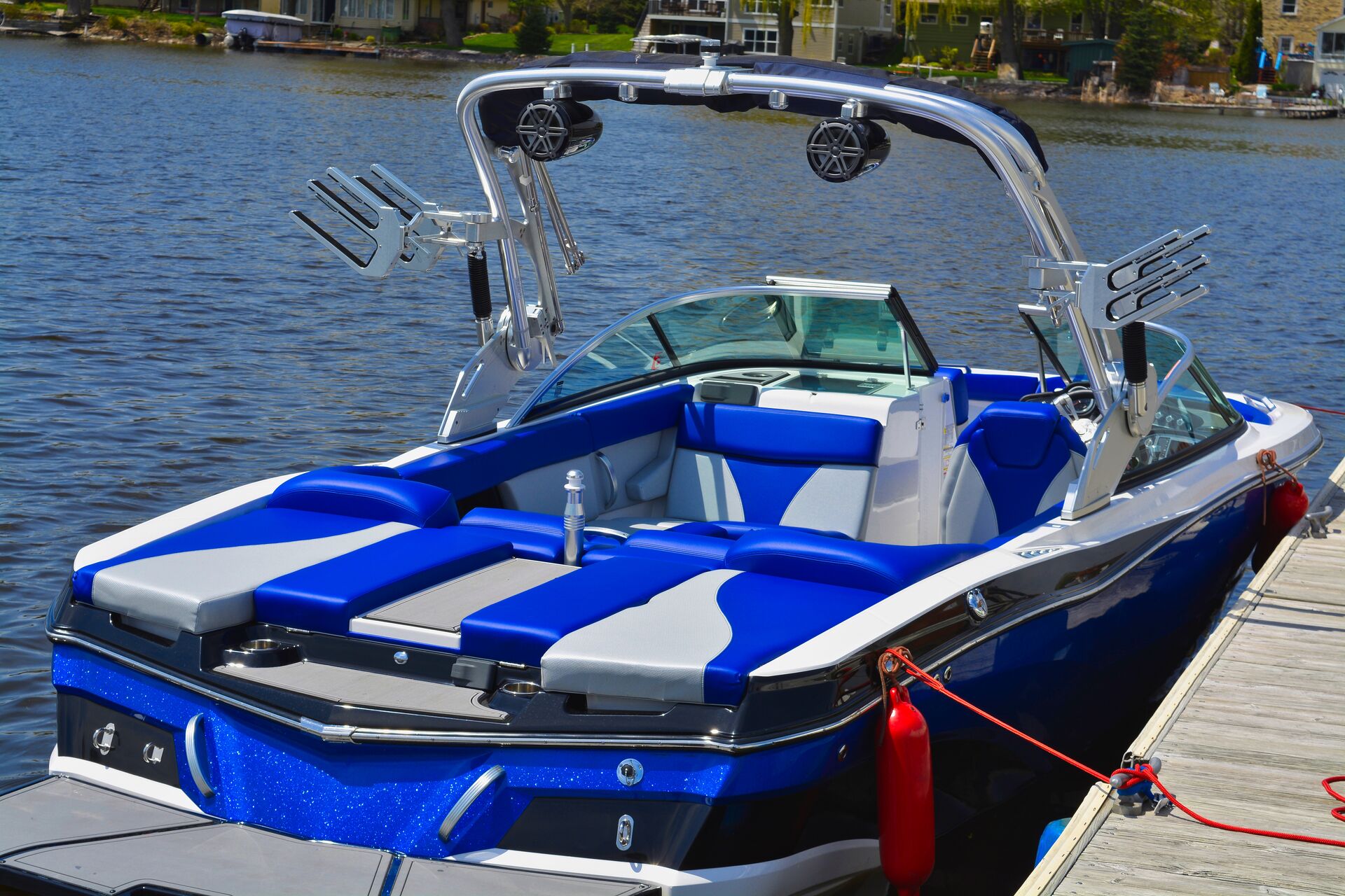 A blue power boat tied to a dock showing the back of boat, boat ventilation system concept.