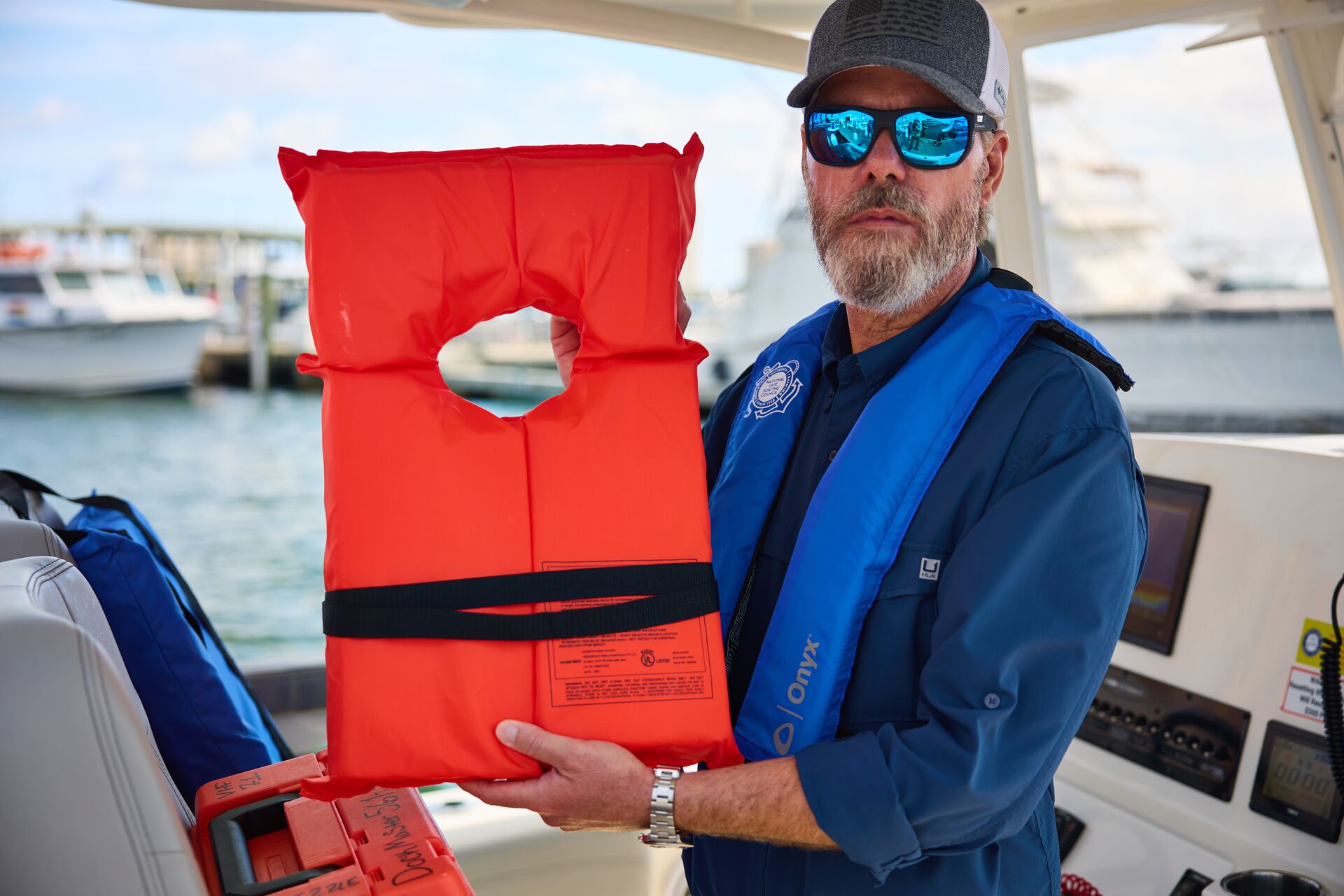 A man wearing and holding a life jacket, boat safety equipment concept. 