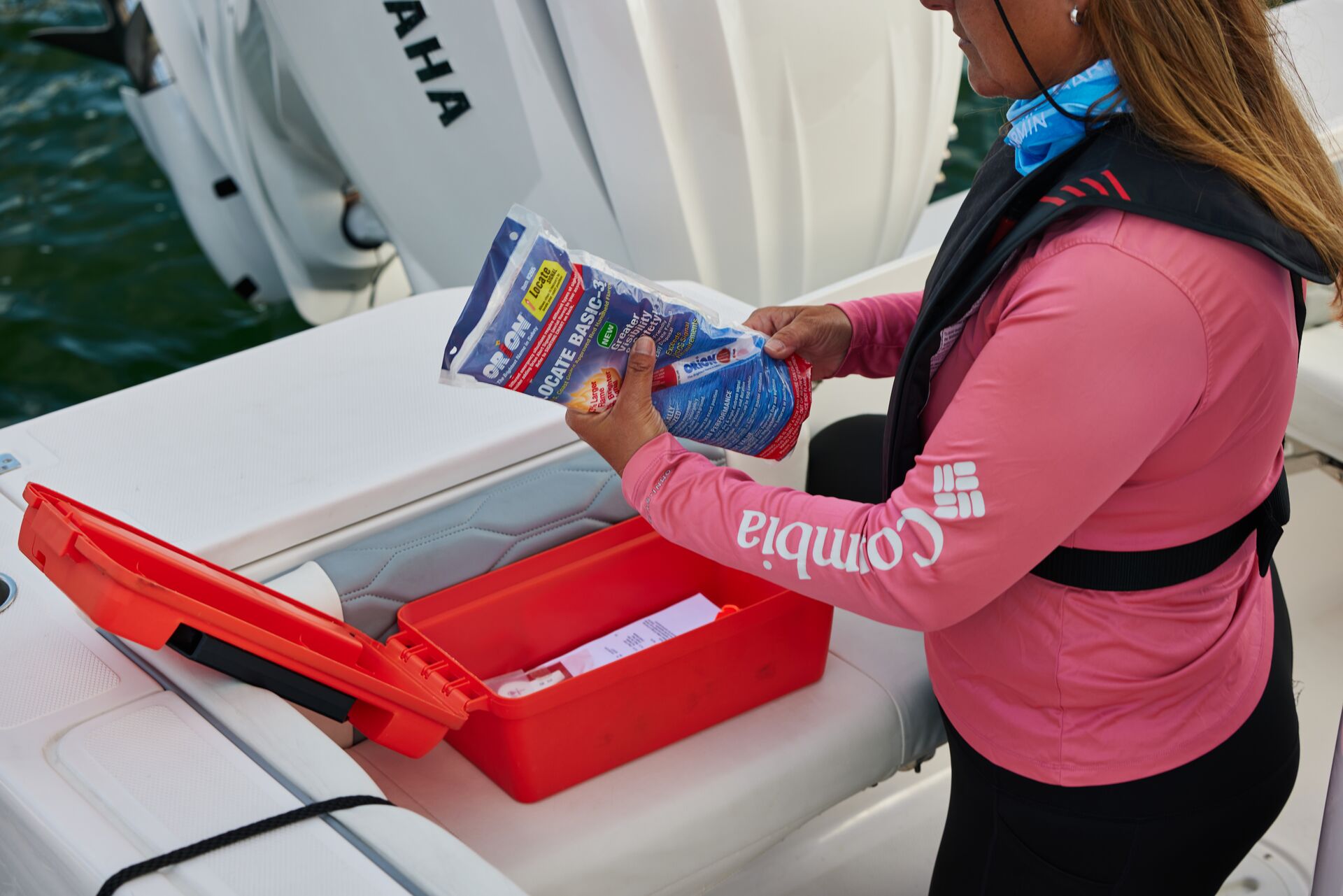 A woman checks a visual distress signal for a boat. 
