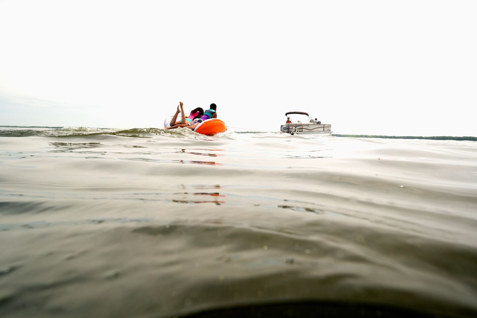 A person on an inflatable in the water near a boat, rendering aid concept. 