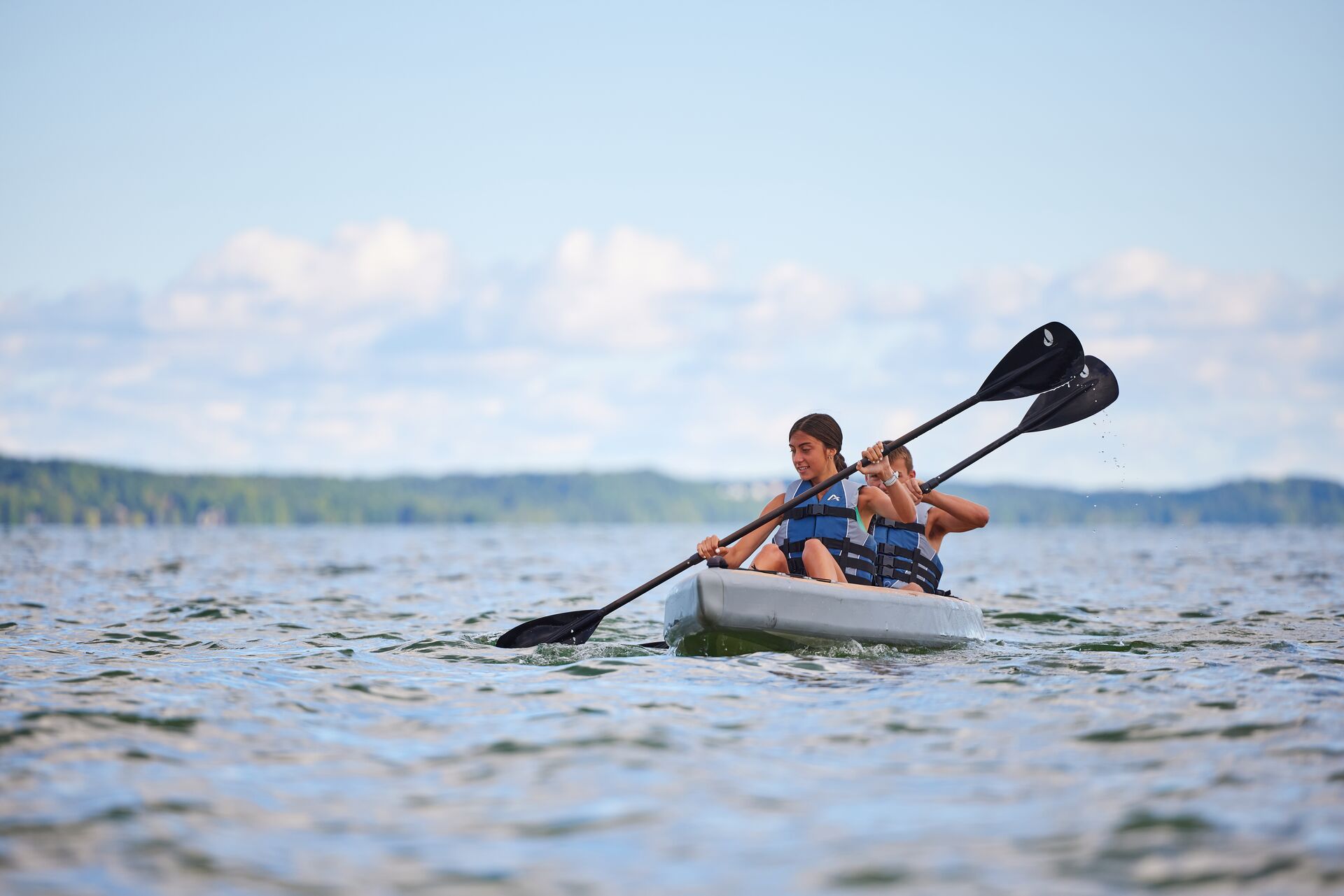 Two people paddle a canoe, avoid boat capsizing concept.