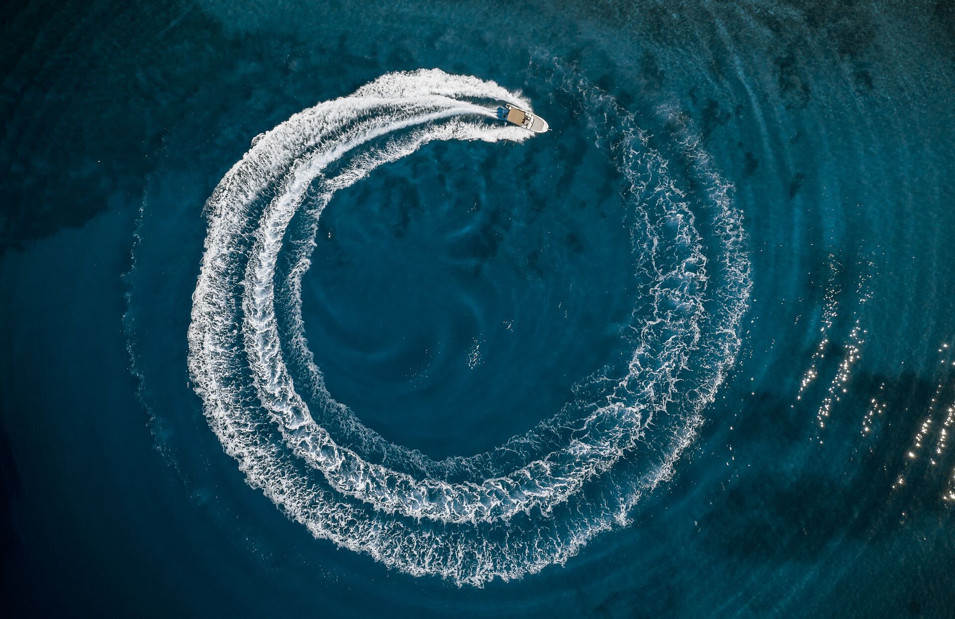 Aerial view of a boat riding in a circle on the water.