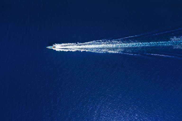  Overhead view of a boat creating a wake on the water. 