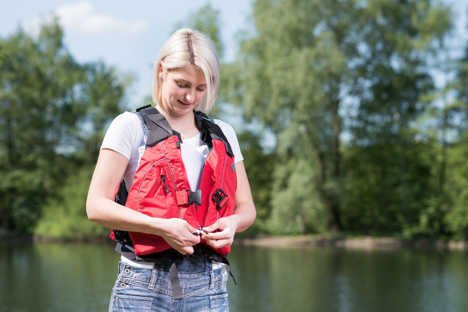 A woman fastens a life jacket, learn about Texas life jacket laws concept. 