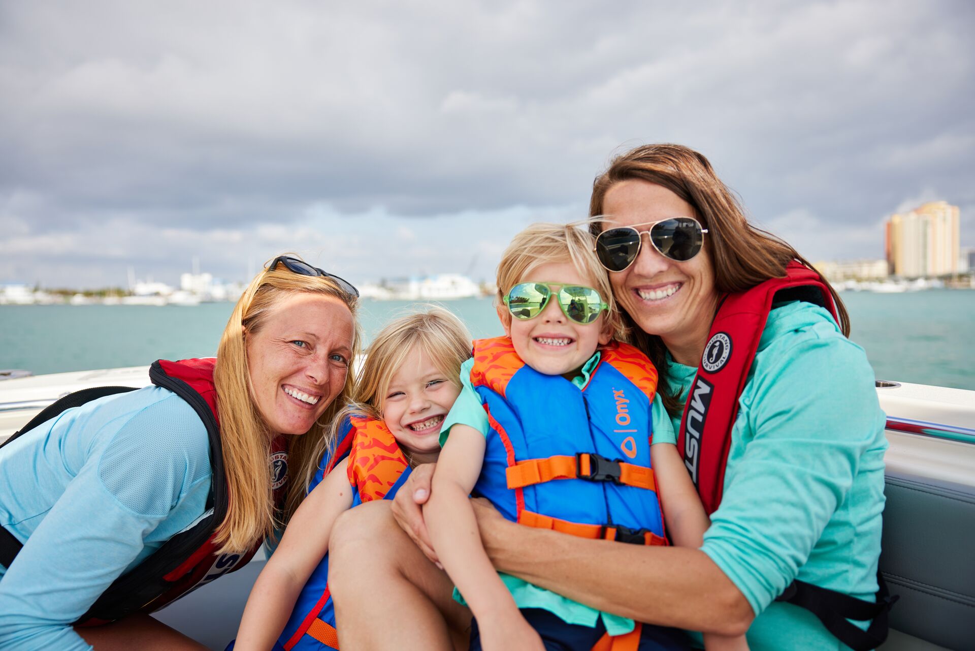 Women and children smile while wearing life jackets on a boat, boating safety tips for kids concept.