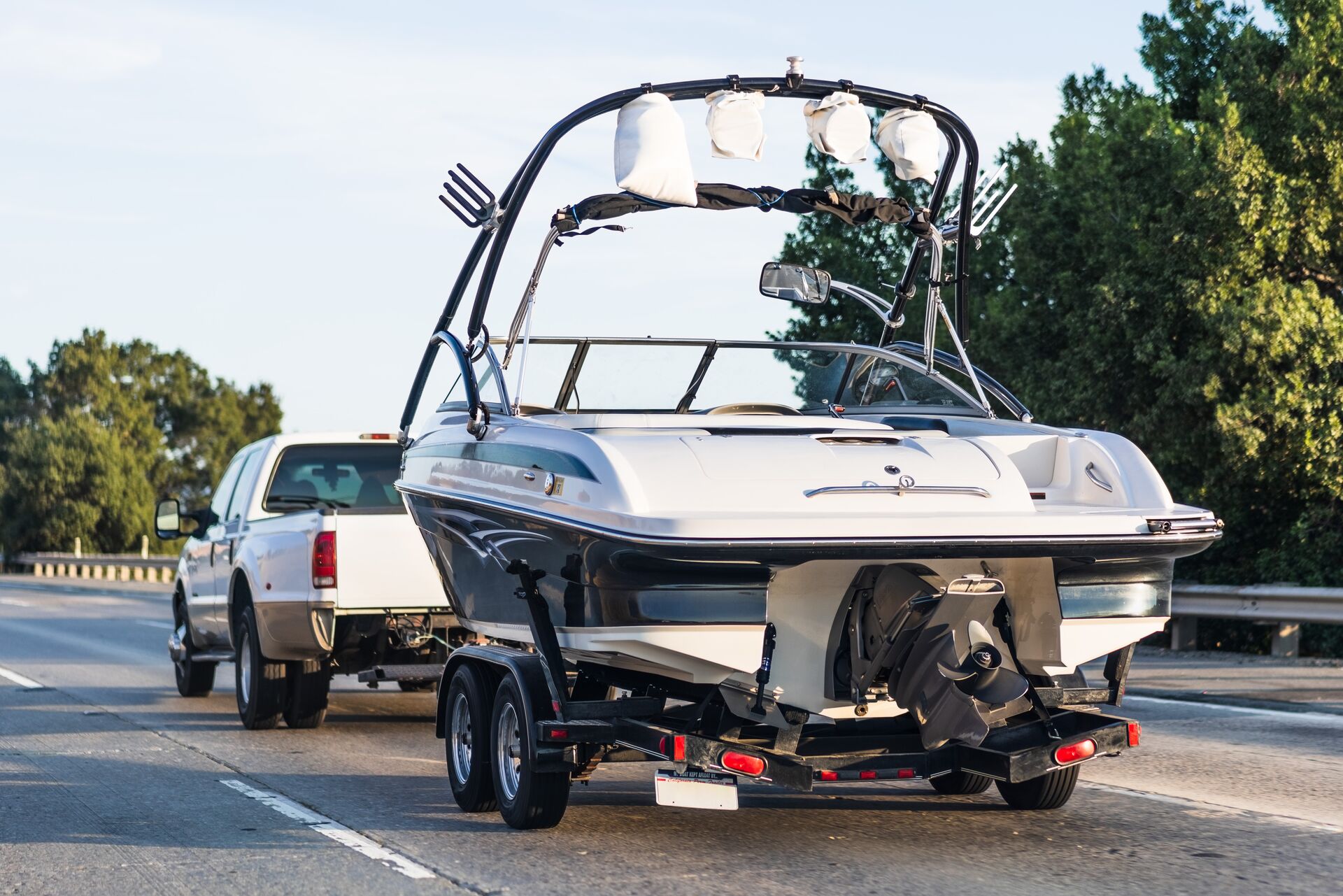 A truck pulls a boat on a trailer.
