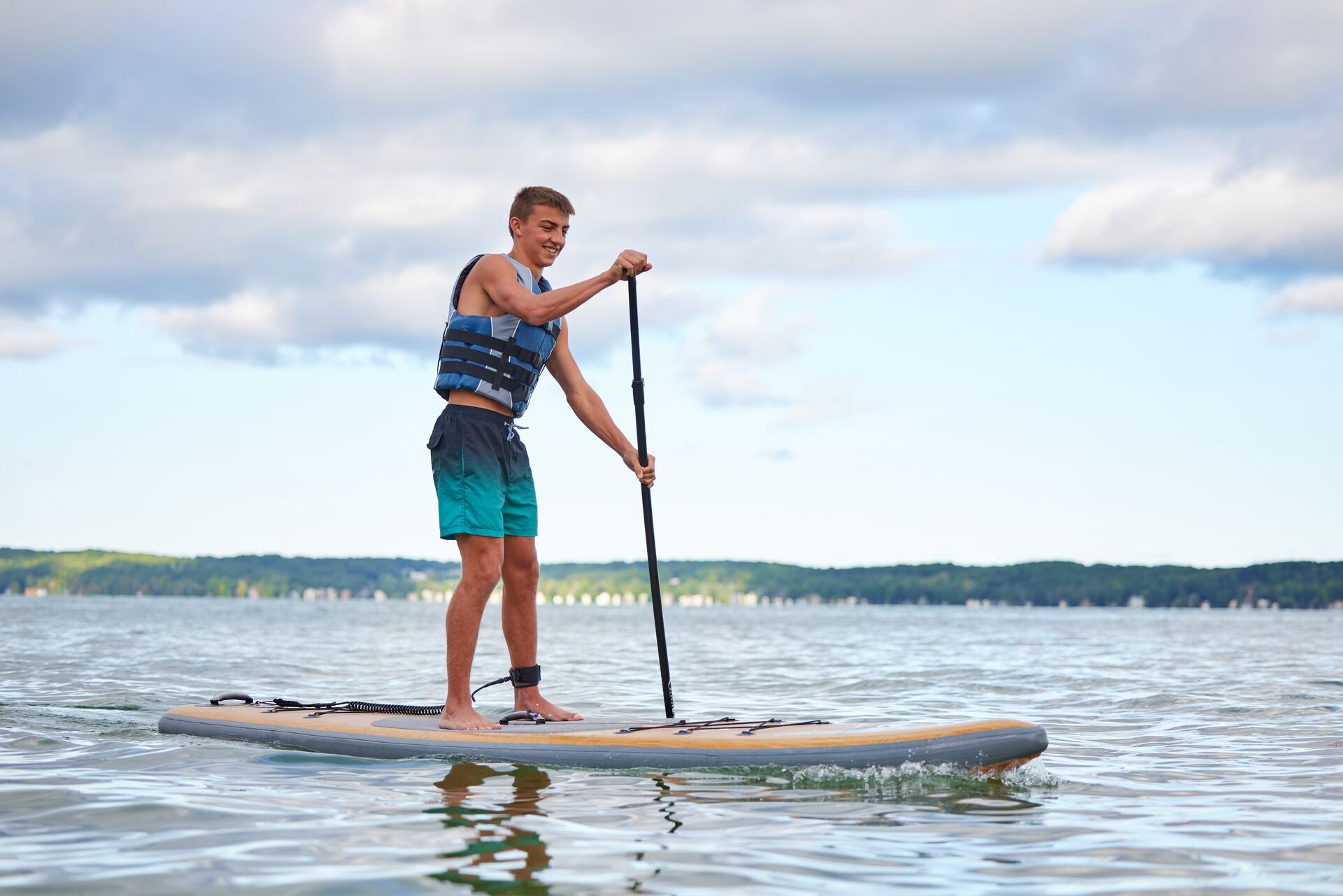 Boy in life jacket on paddleboard, do you need a boating license in California concept. 