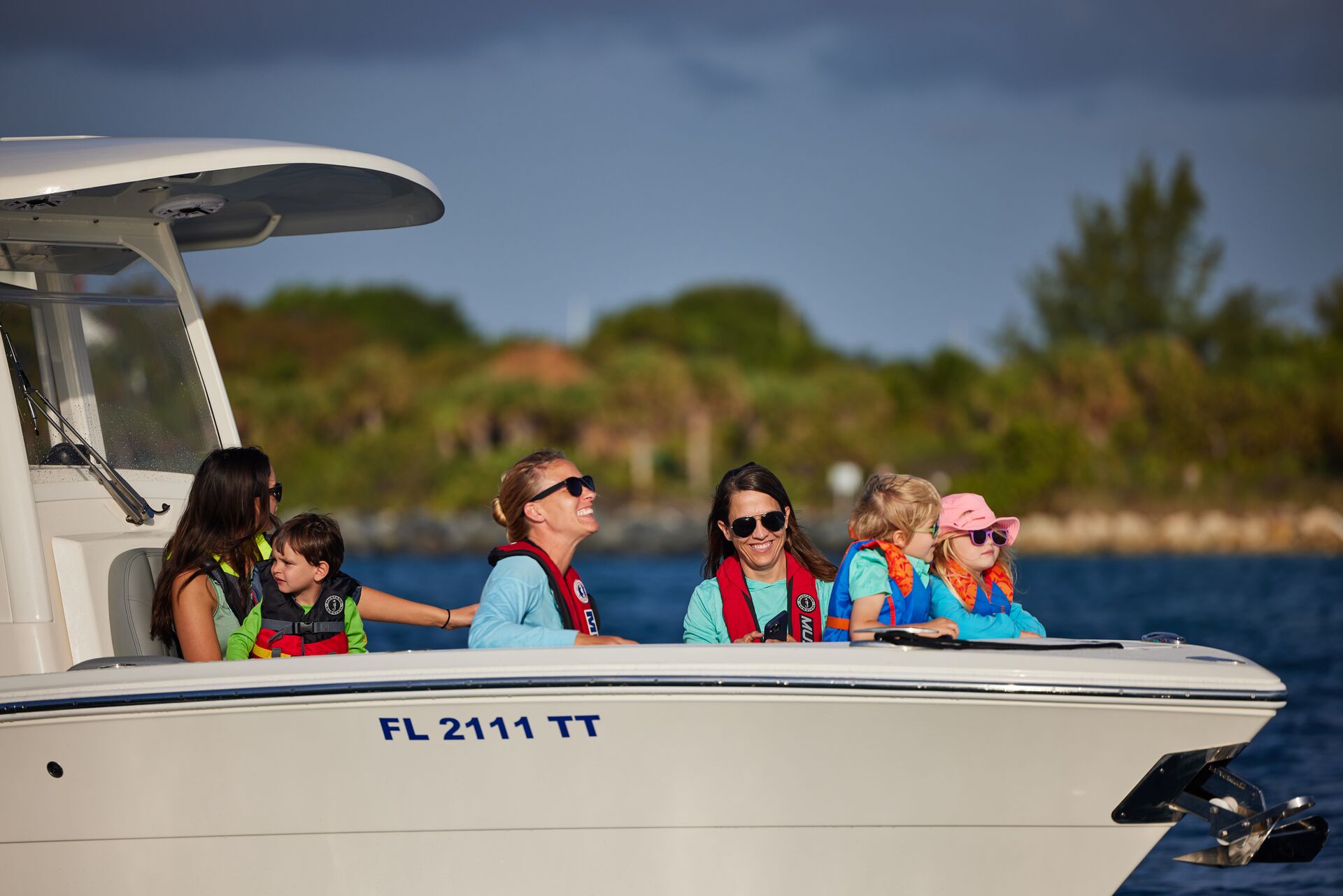 Passengers in a boat wearing life jackets and smiling, California boating laws concept.