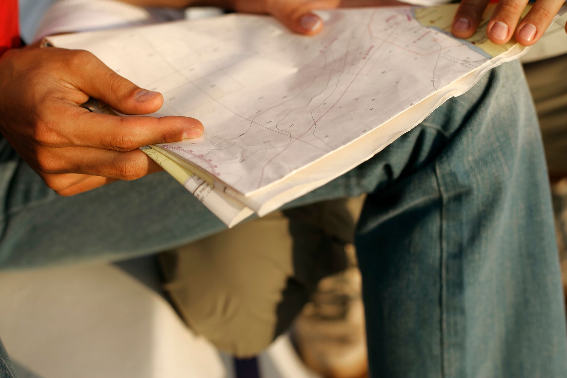 Close-up of someone reading a paper map, how to read marine navigation charts concept.