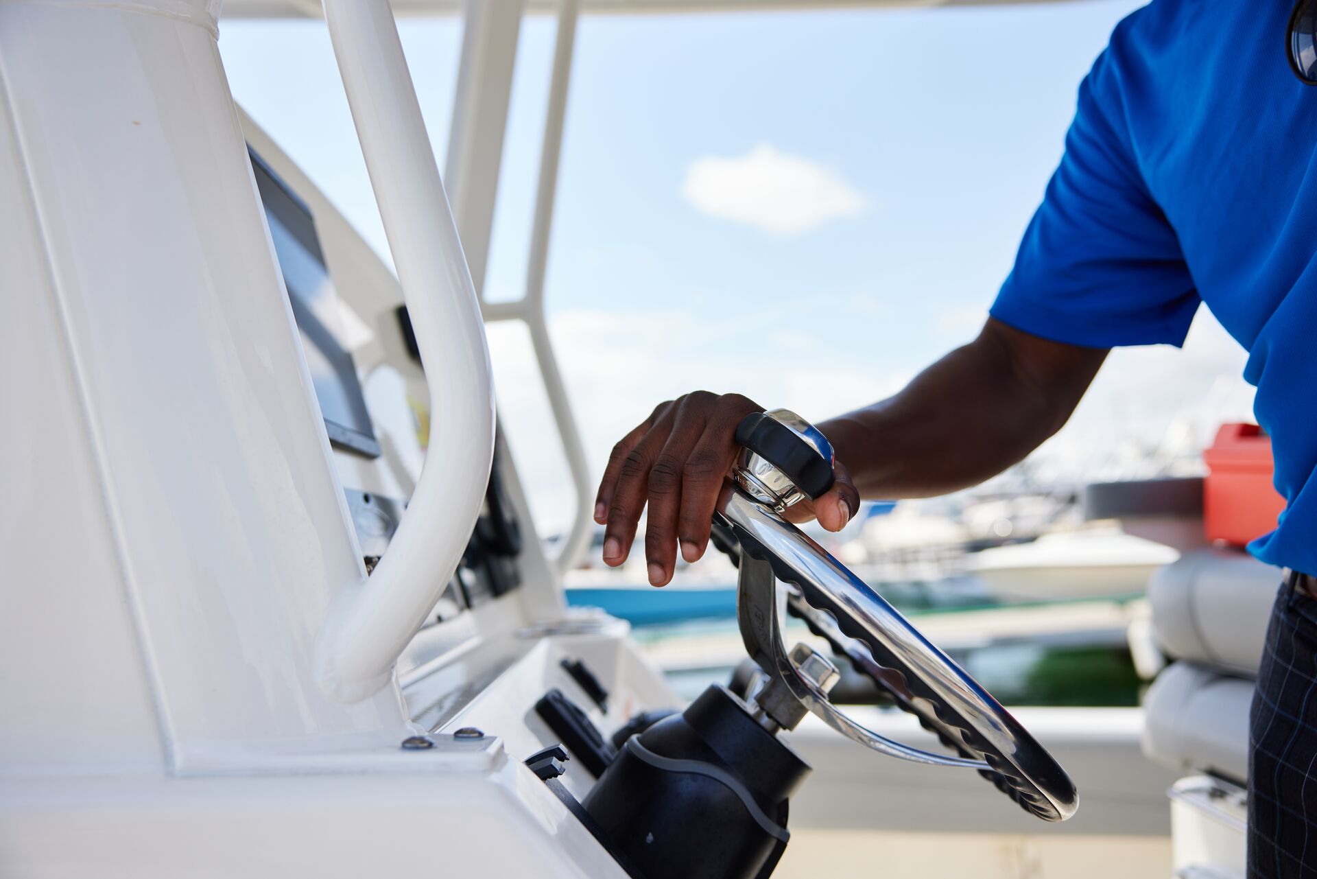 Boat operator's hand on boat's helm, boat spring commissioning concept. 