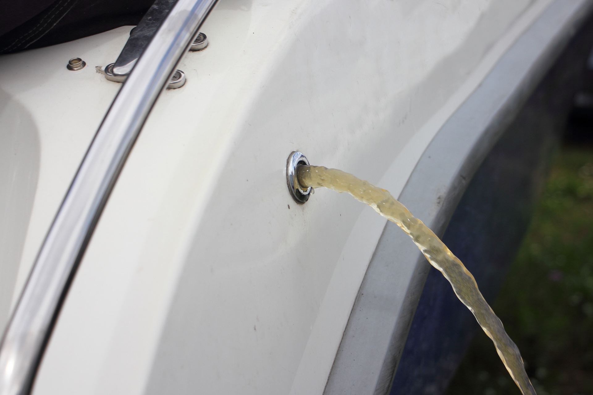 Water emptying from boat's bilge, de winterizing a boat checklist concept. 
