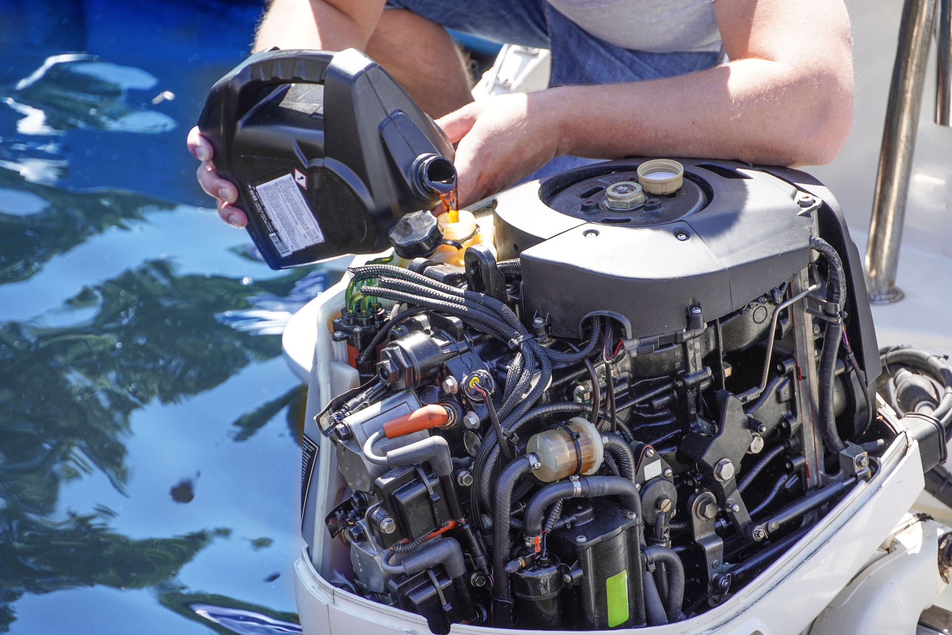 Boater puts oil into boat engine, boat spring commissioning concept. 
