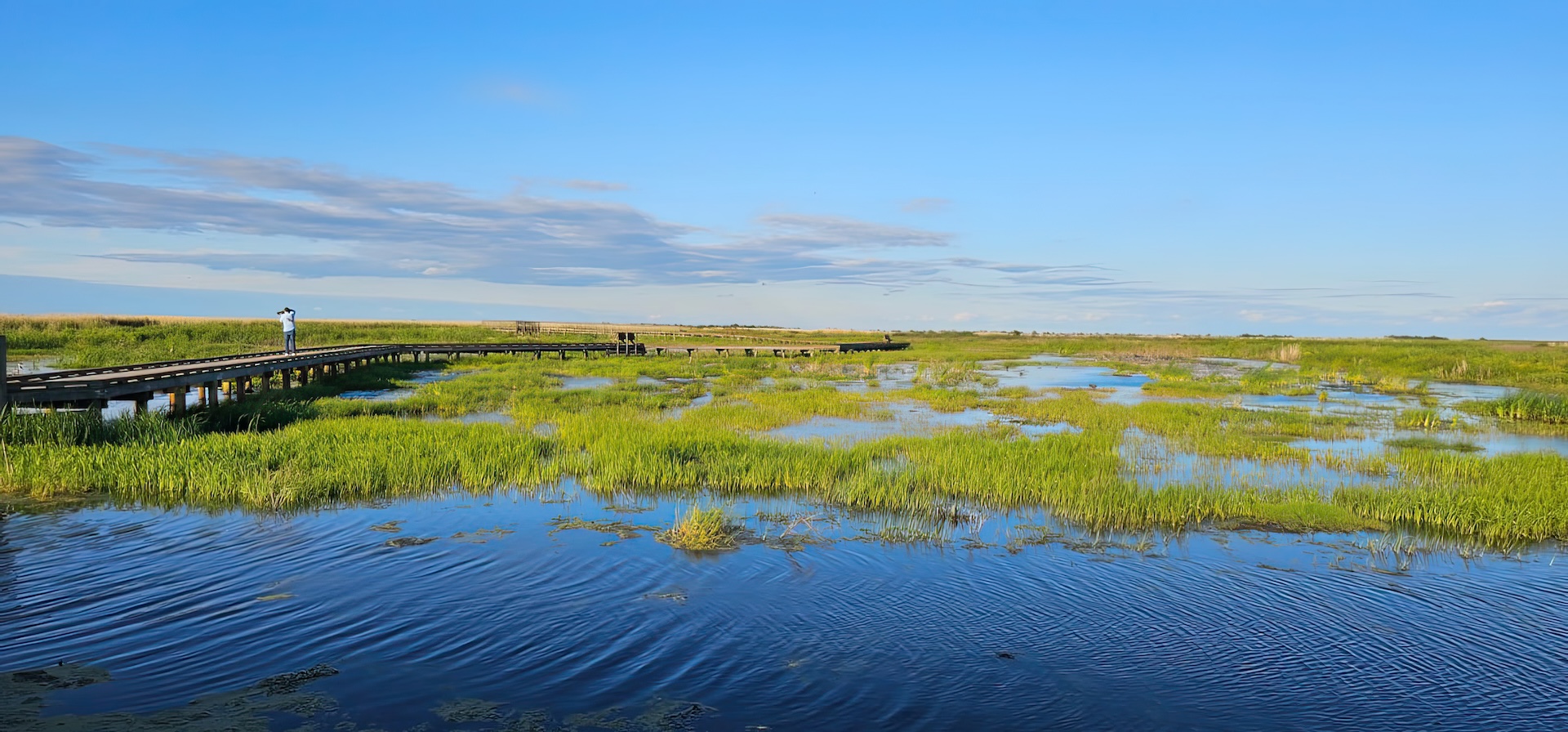 Wide view of a marshy area and wooden bridge, Anahuac National Wildlife Refuge Fishing​ concept.