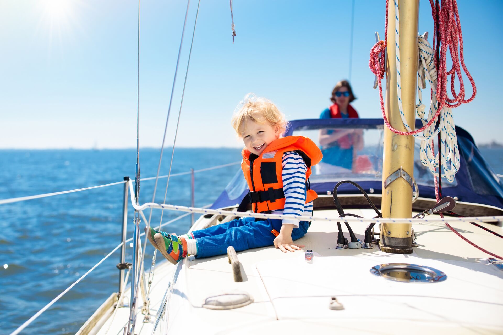 Child in a lifejacket on a sailboat.