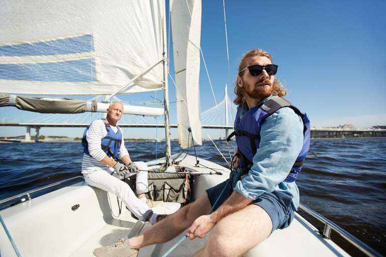 Two men on a sailboat, attend Summer Sailstice concept. 