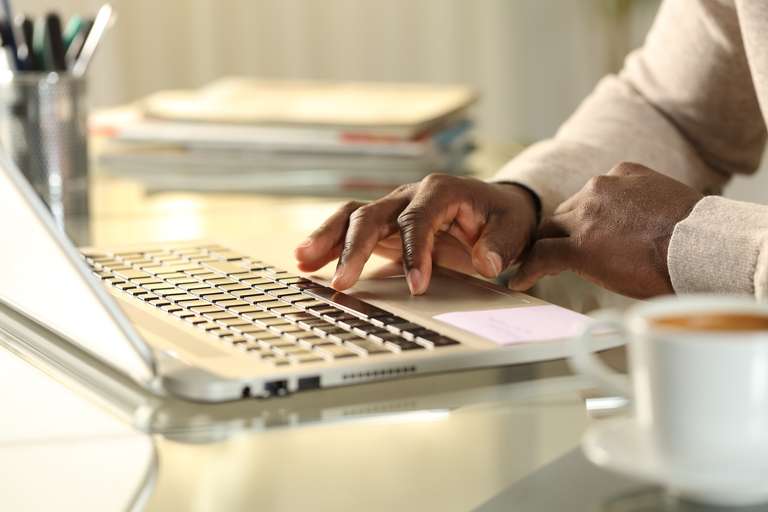 Close-up of a hand using a laptop keyboard, online safety courses for boating concept. 