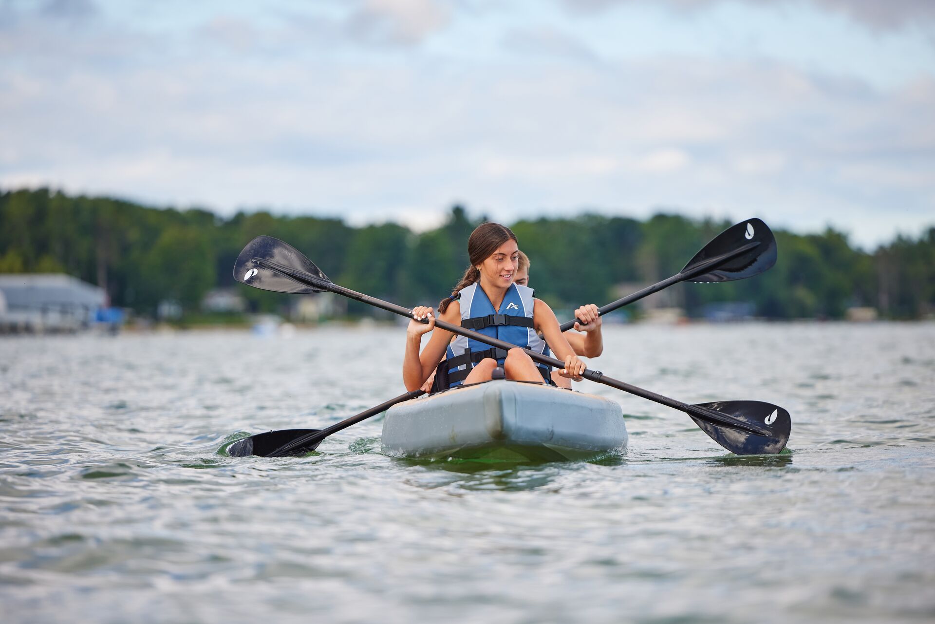 Two people paddling a kayak, what is the best life vest for kayaking concept. 
