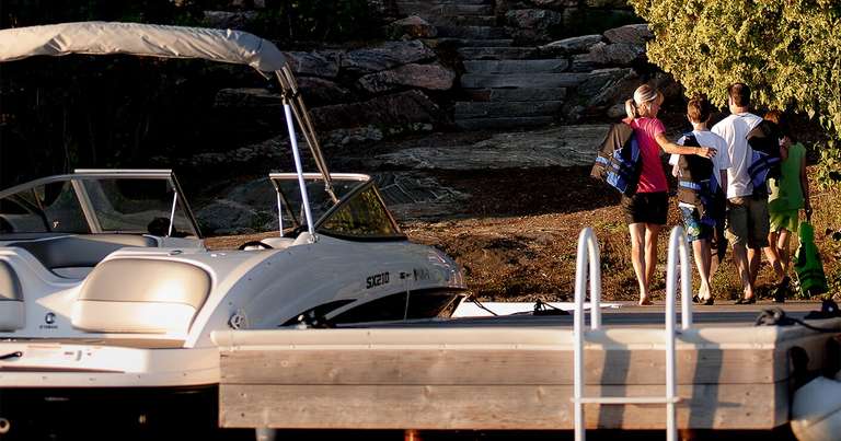 Family walks away from boat at dock, how to tie a boat to a dock overnight concept. 