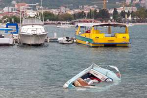 Boat sinking in the water, avoid common boating accident injuries concept.
