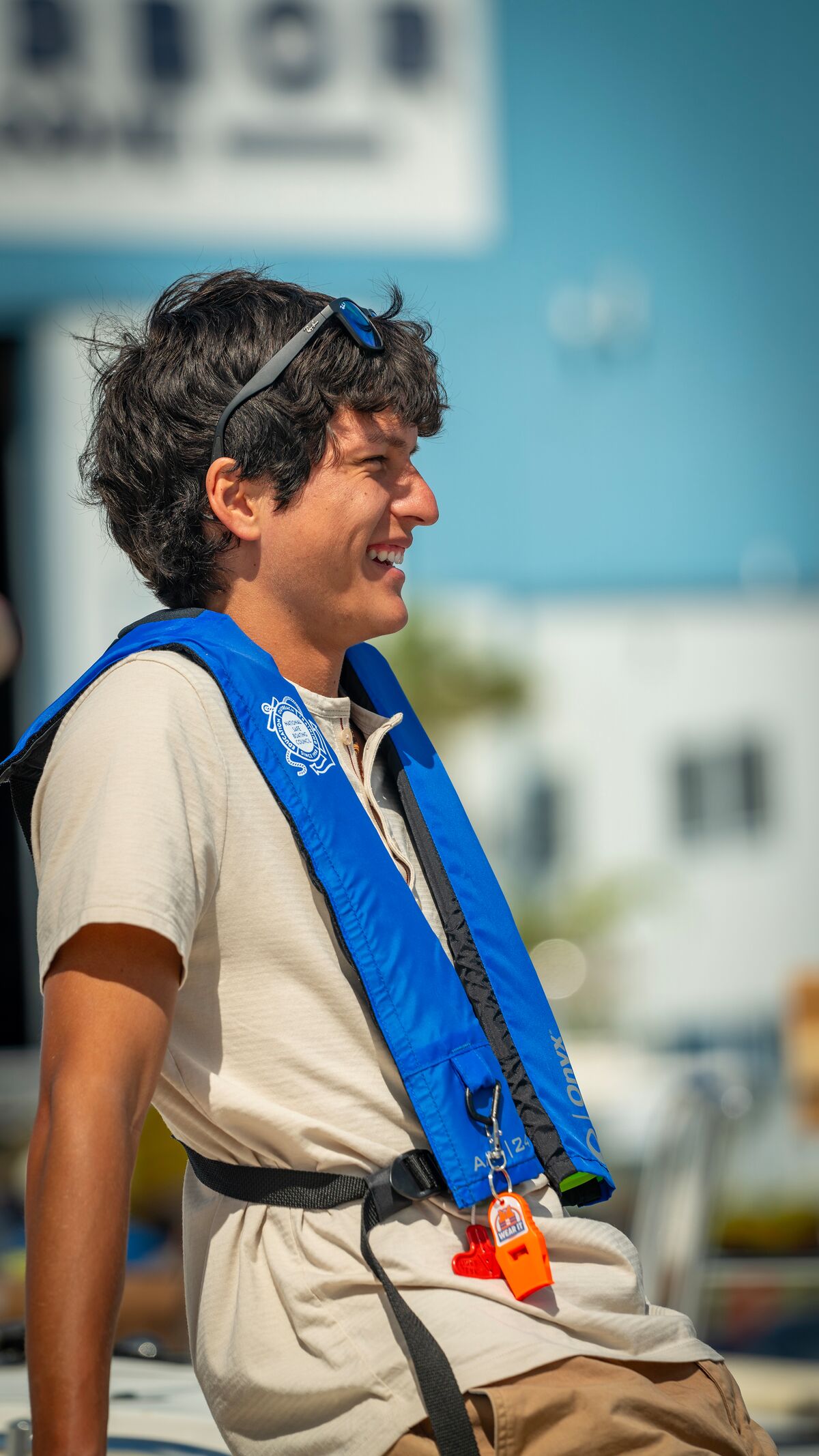 Male boater wearing life jacket while smiling on dock. 
