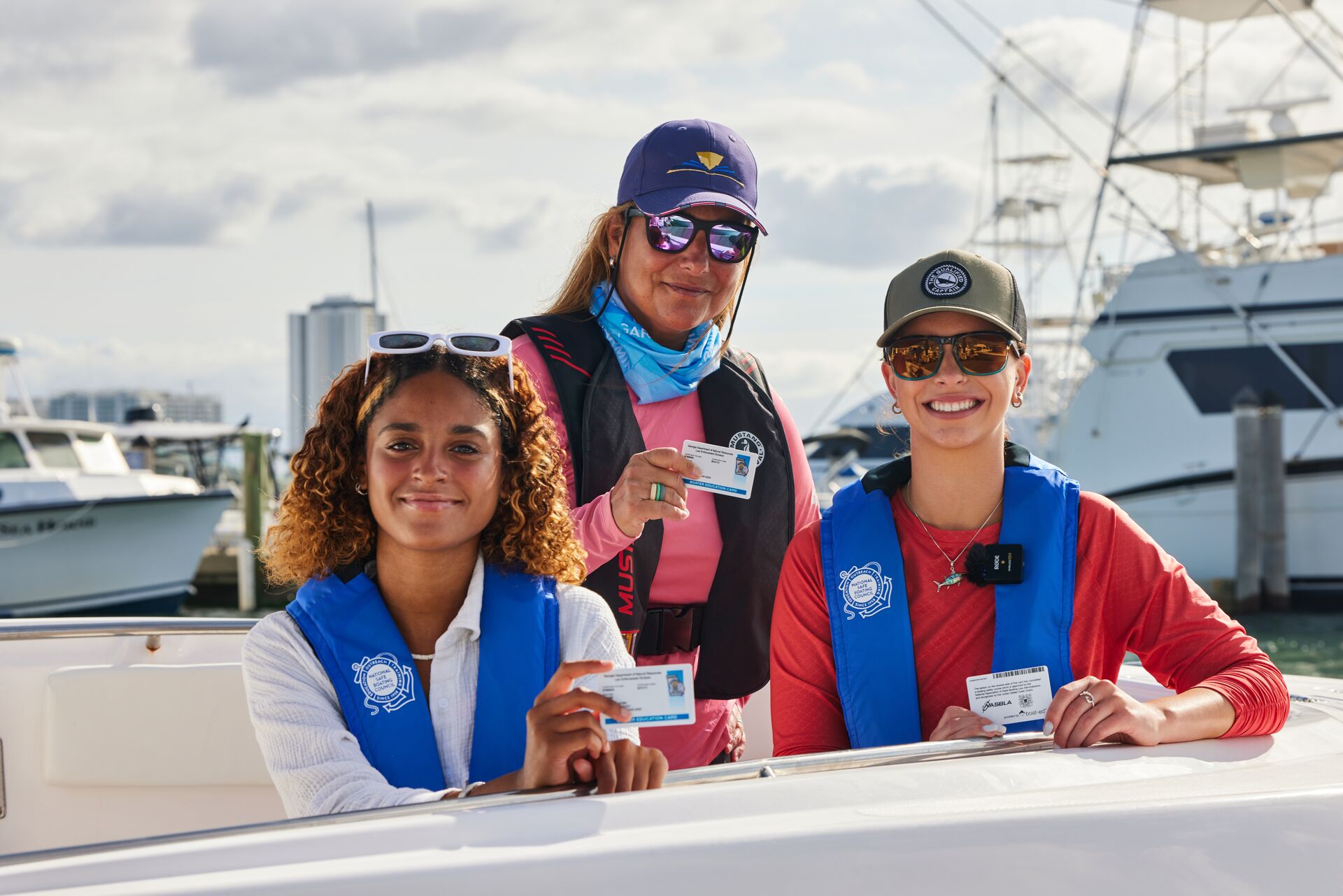Smiling women in life jackets with boater cards, learn boating terminology and more concept. 