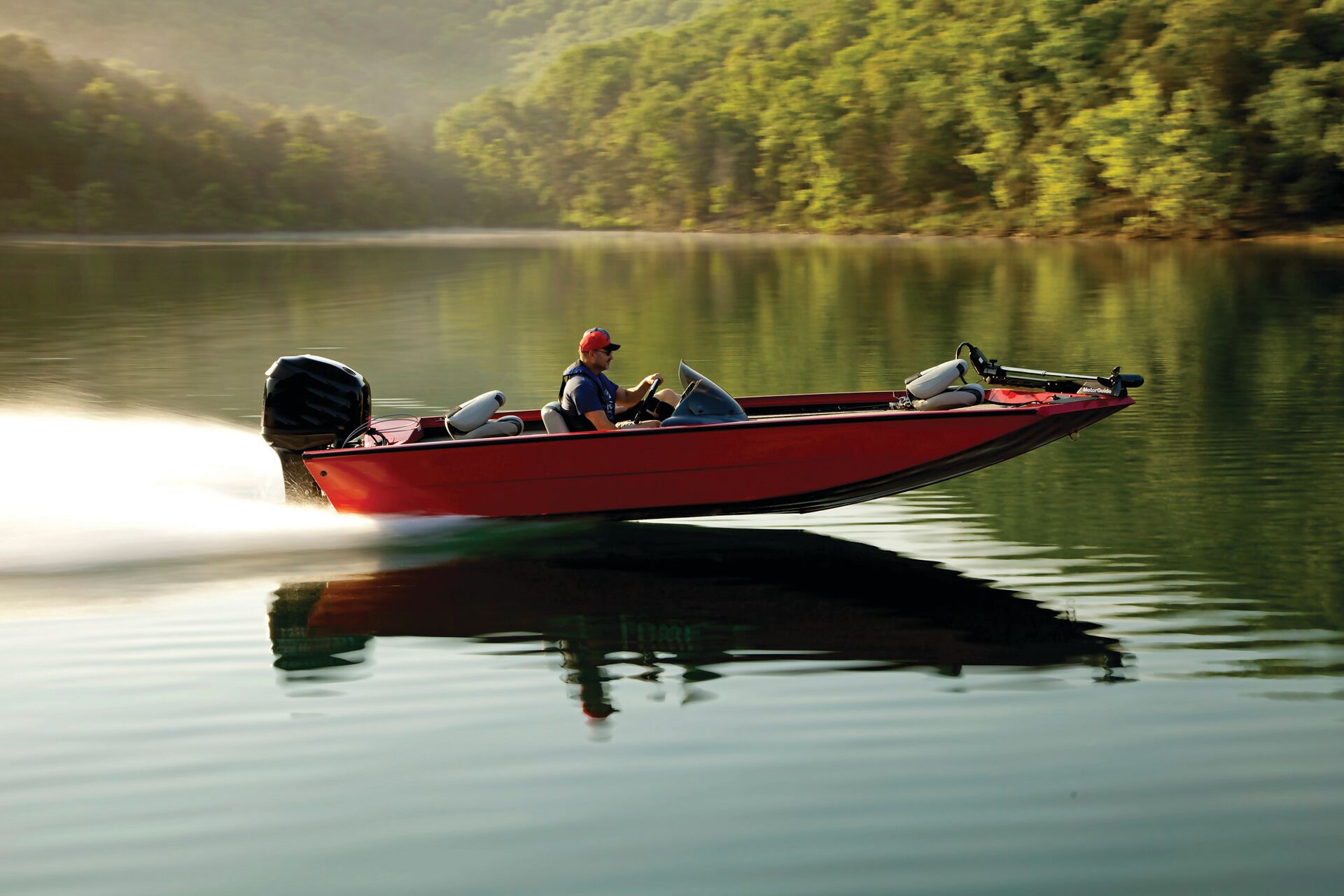 Person driving red fishing boat on water, boating safety regulations concept. 