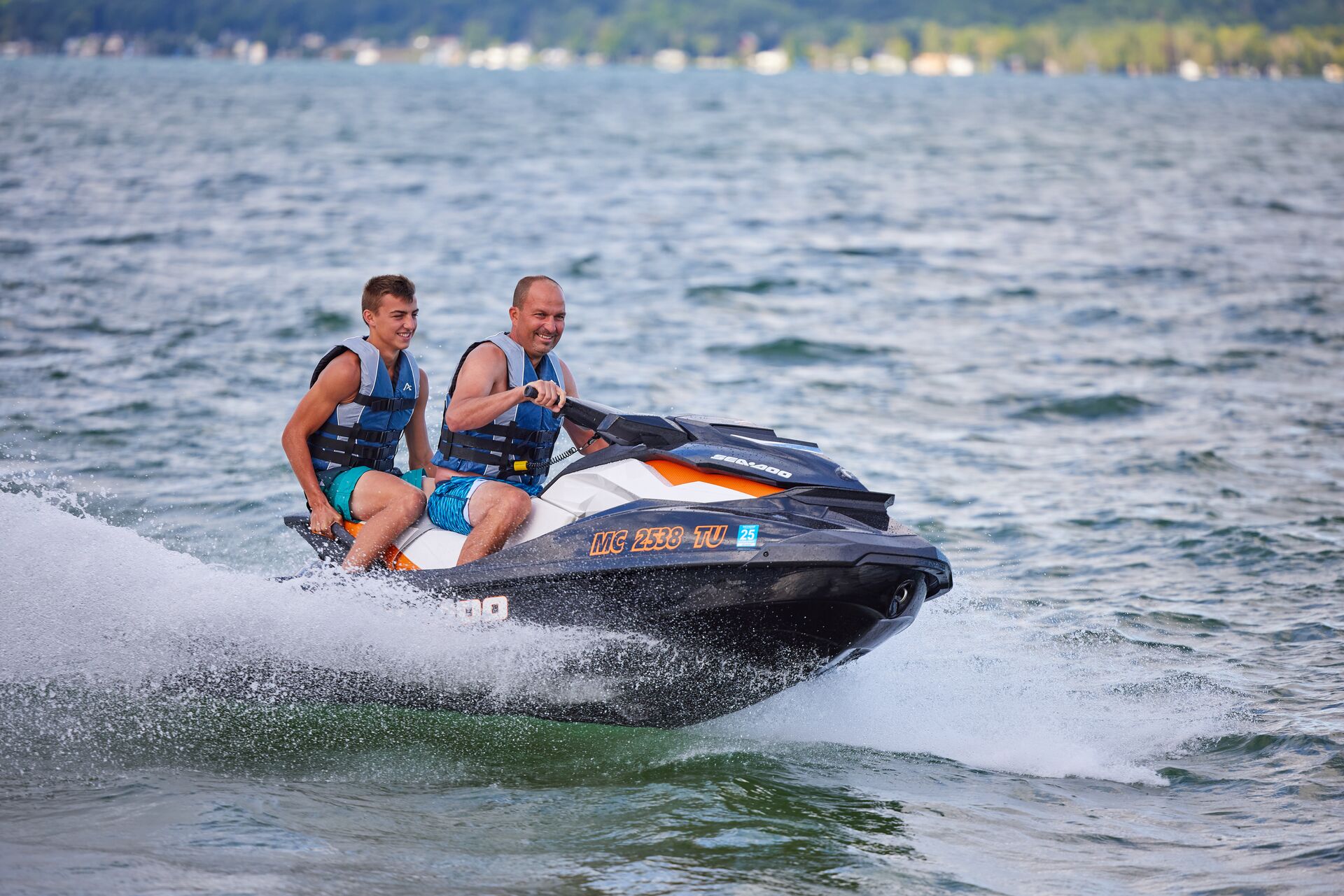 Man drives jet ski with kid on board, jet ski license California concept. 